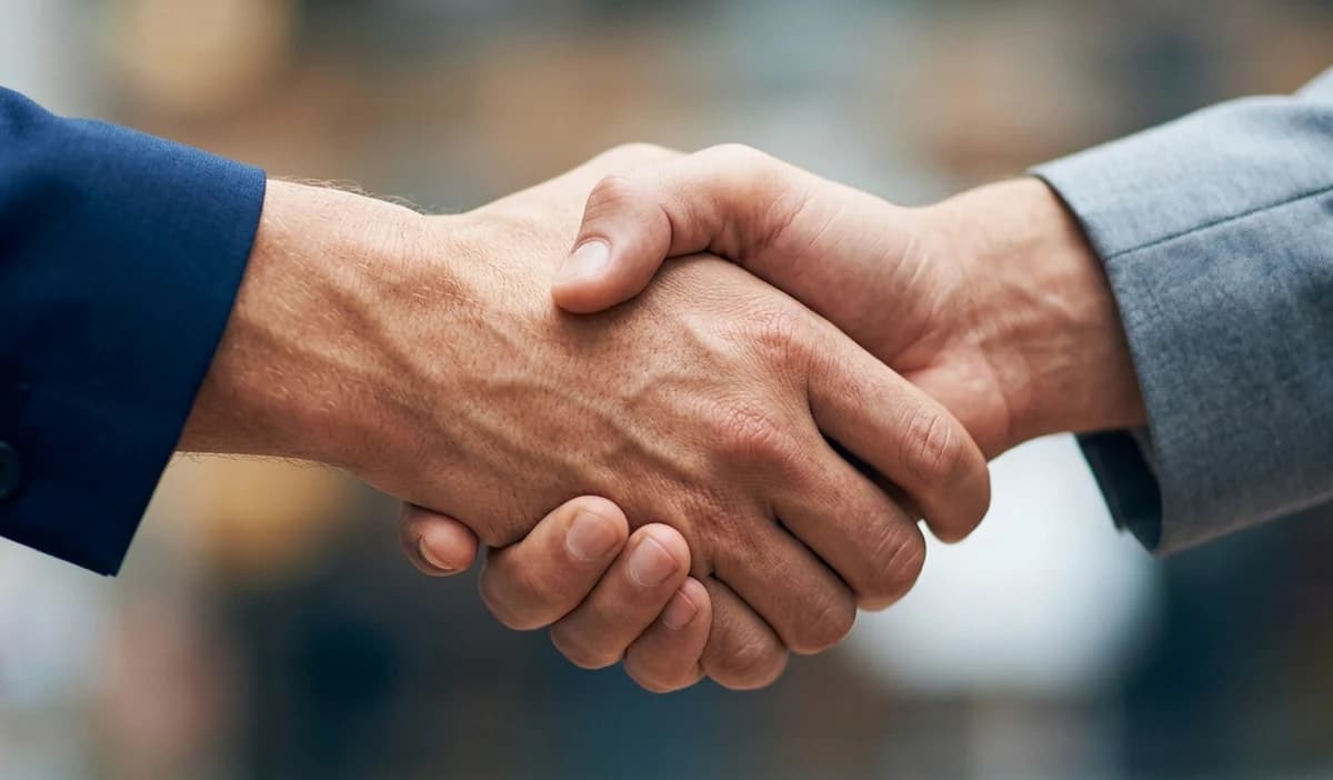 Stretta di mano tra musicista e sposo che firmano il contratto per suonare al matrimonio